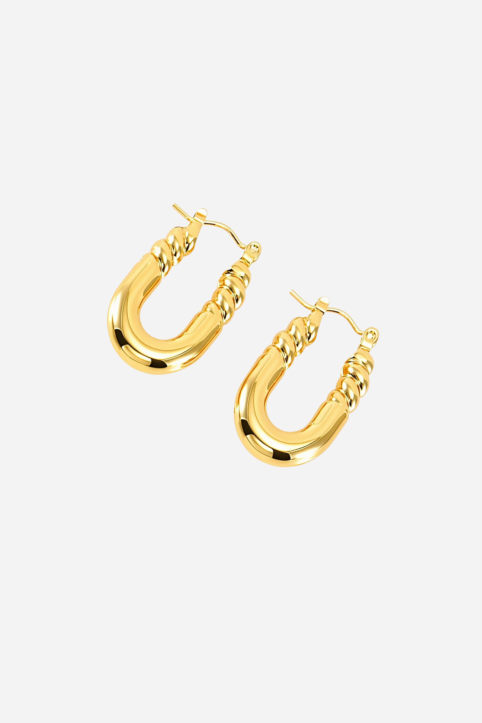 Angled view of U-shaped twisted hoop earrings made from stainless steel with a mirror-polished PVD 18K gold plated finish, highlighting the curved base and intricate twisted upper design – GLISTIA.