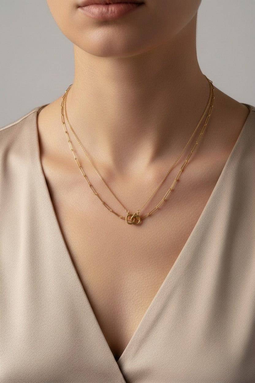 Close-up detail of Unity Handcuff layered necklace in 18K PVD gold plated stainless steel showing layered chains and handcuff motif