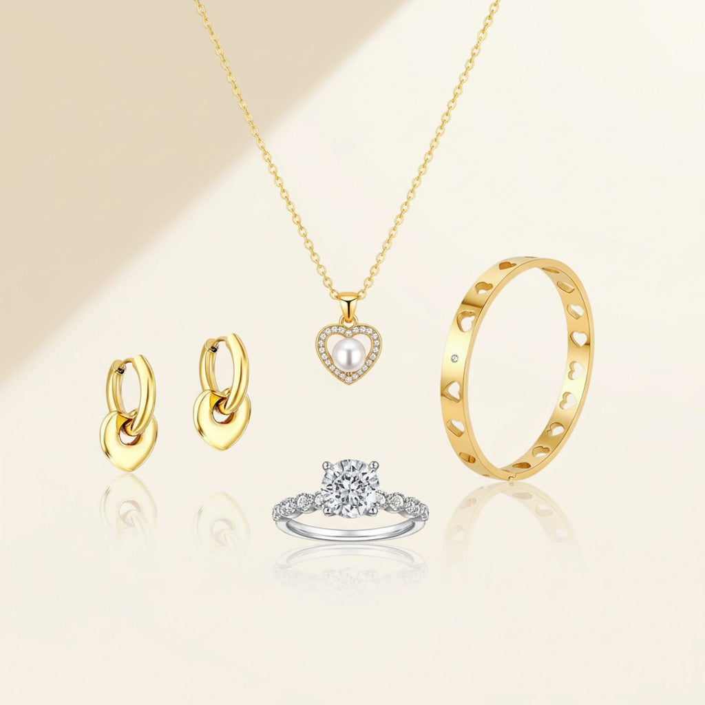 Luxury Valentine’s Day jewellery set featuring a heart pendant necklace, heart hoop earrings, open heart bangle, and sterling silver solitaire ring by Glistia