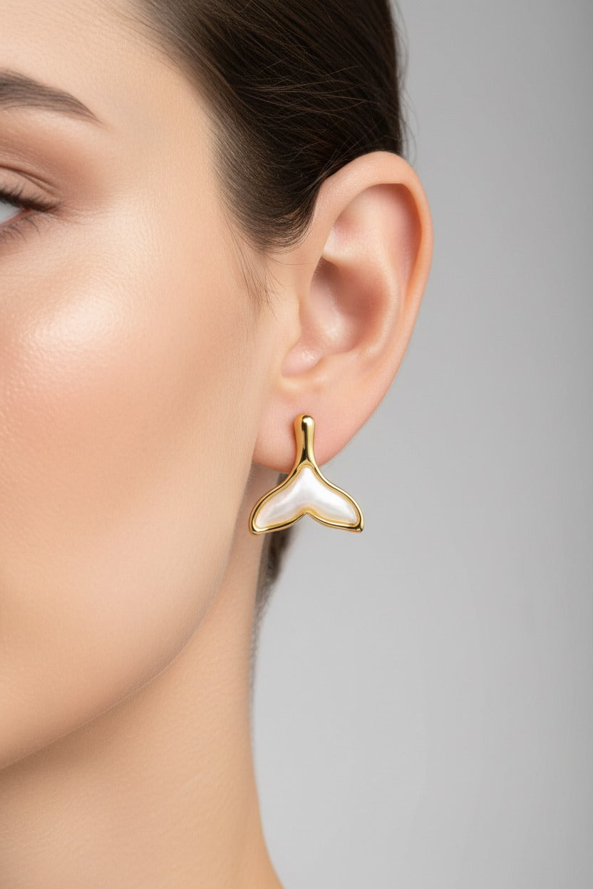 Whale tail stud earrings crafted from stainless steel with 18K PVD gold plating, featuring a pearly resin inlay and polished gold frame