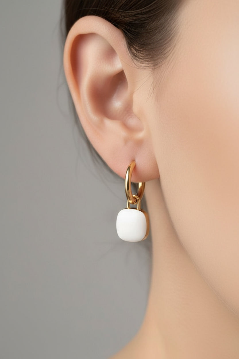 White charm drop hoop earrings in 18K PVD gold plated stainless steel worn on ear, minimalist everyday jewellery