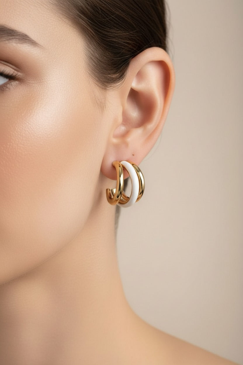 White and gold double C-hoop earrings crafted from stainless steel with 18K PVD gold plating and smooth white enamel, featuring a layered dual-hoop design