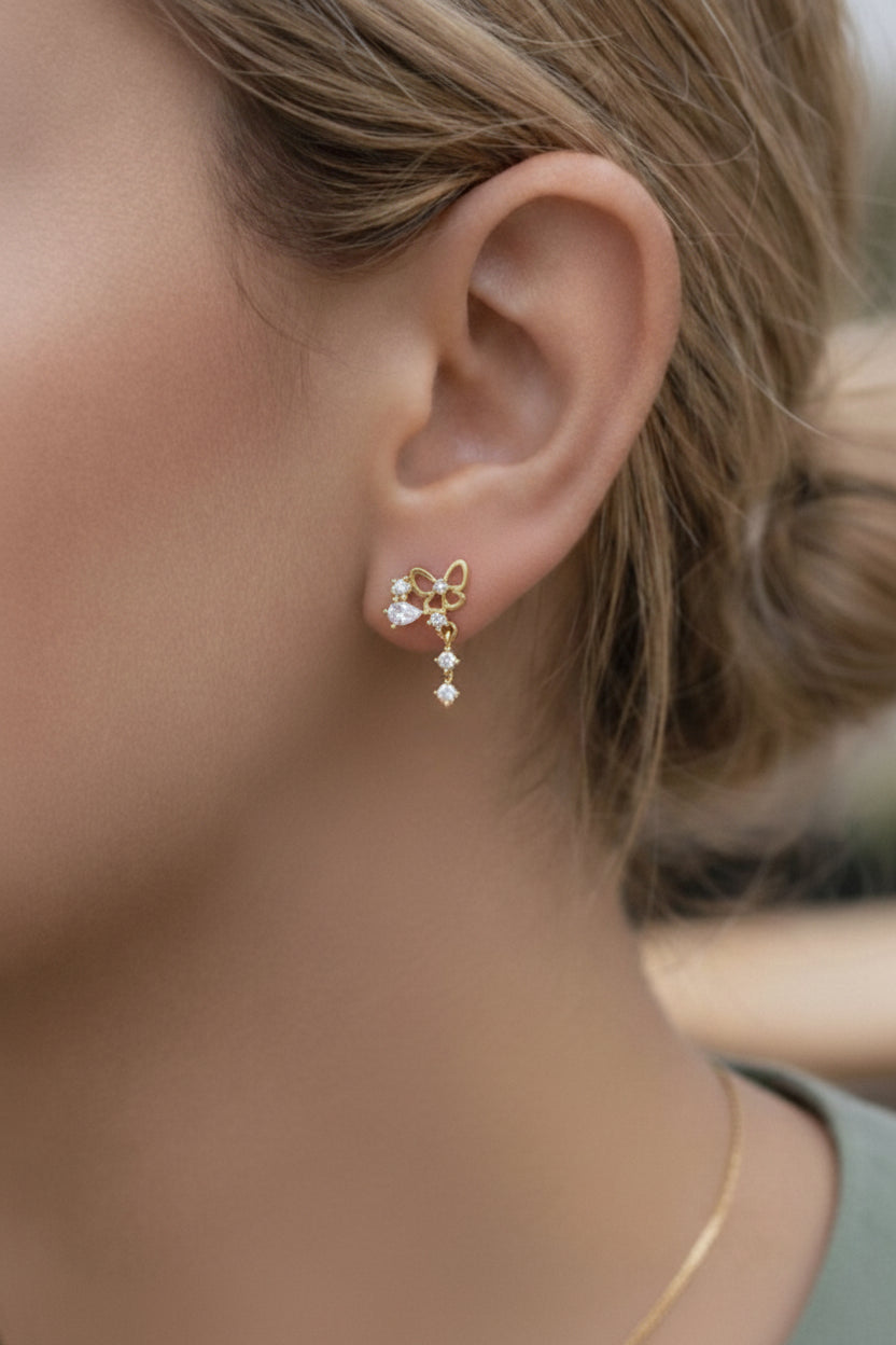 Gold butterfly drop piercing earrings featuring sparkling cubic zirconia stones in a delicate trailing design