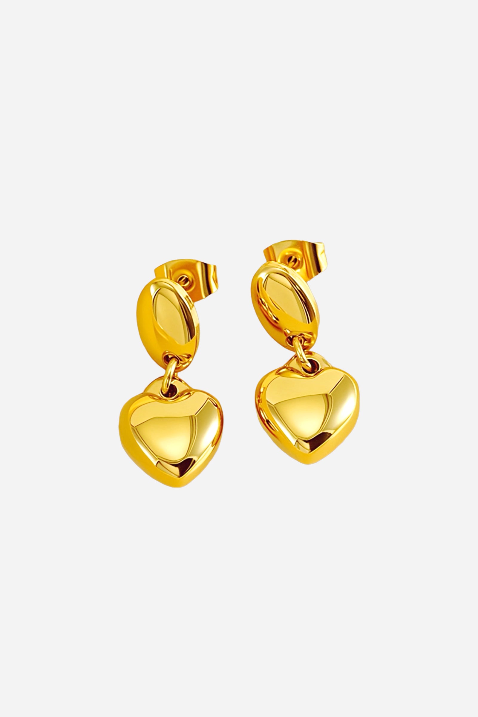 Close-up view of dangle heart earrings crafted from stainless steel with a polished PVD 18K gold plated finish, featuring smooth rounded hearts suspended from oval studs – GLISTIA.