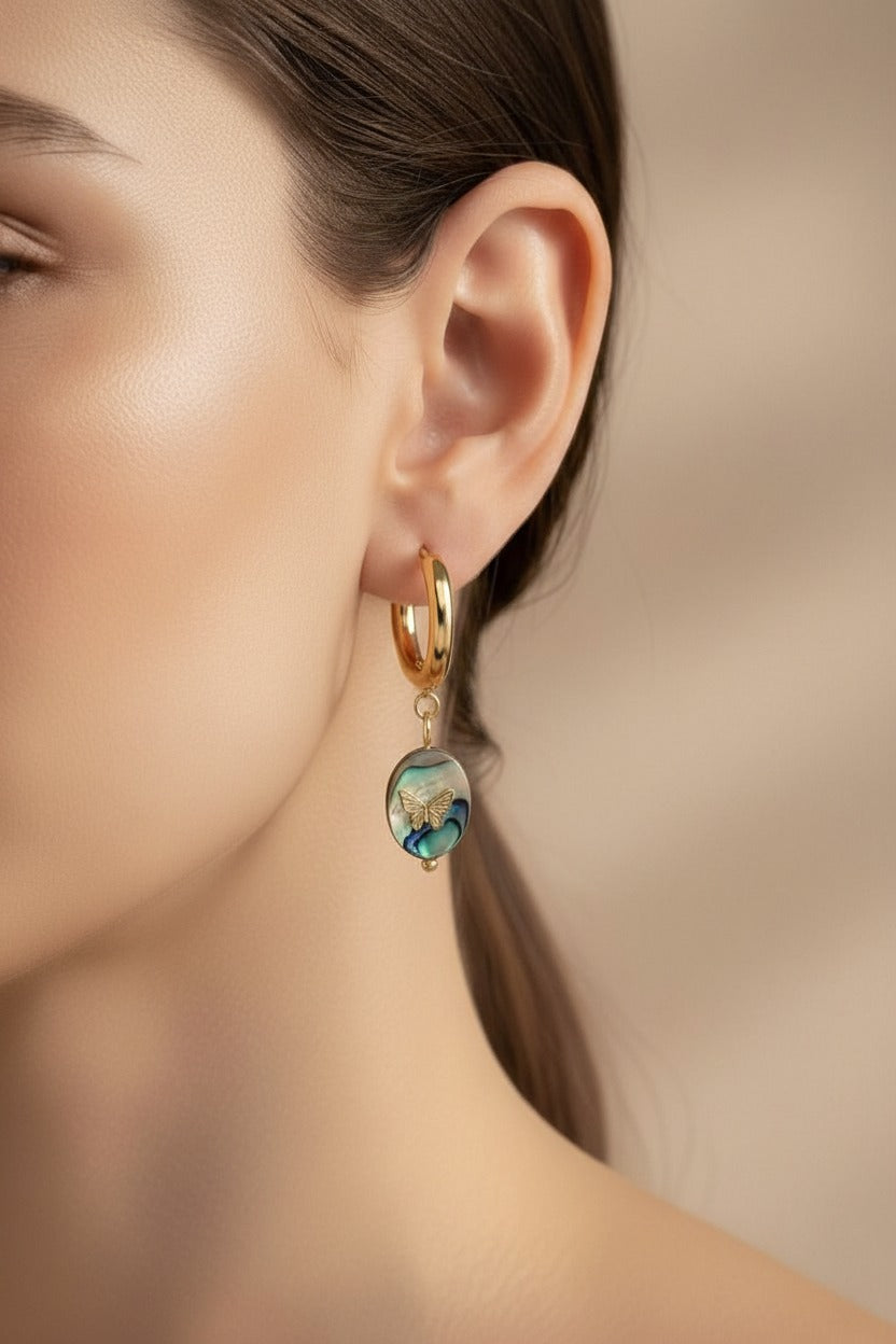 Abalone shell butterfly drop earrings crafted from stainless steel with 18K PVD gold plating, featuring iridescent abalone shell charms and a gold butterfly accent.
