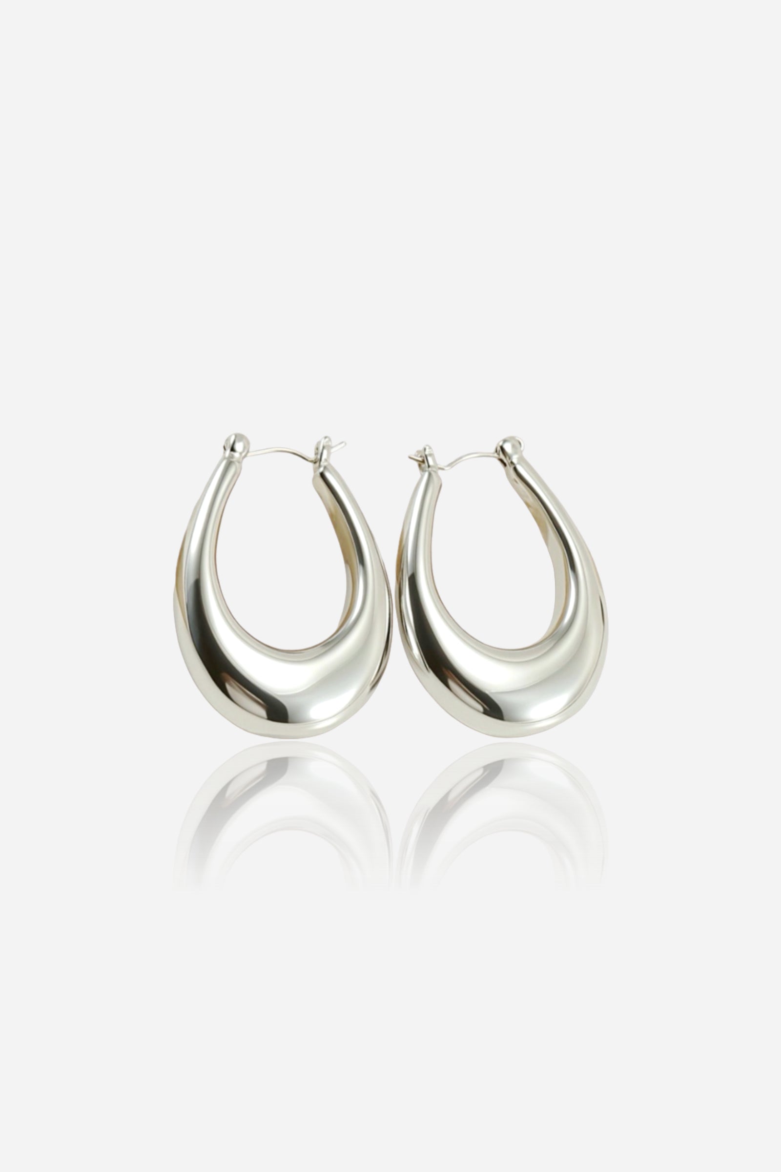 Front view of chunky silver hoop earrings featuring a bold curved silhouette, crafted from stainless steel with a high-shine polished silver finish – GLISTIA.