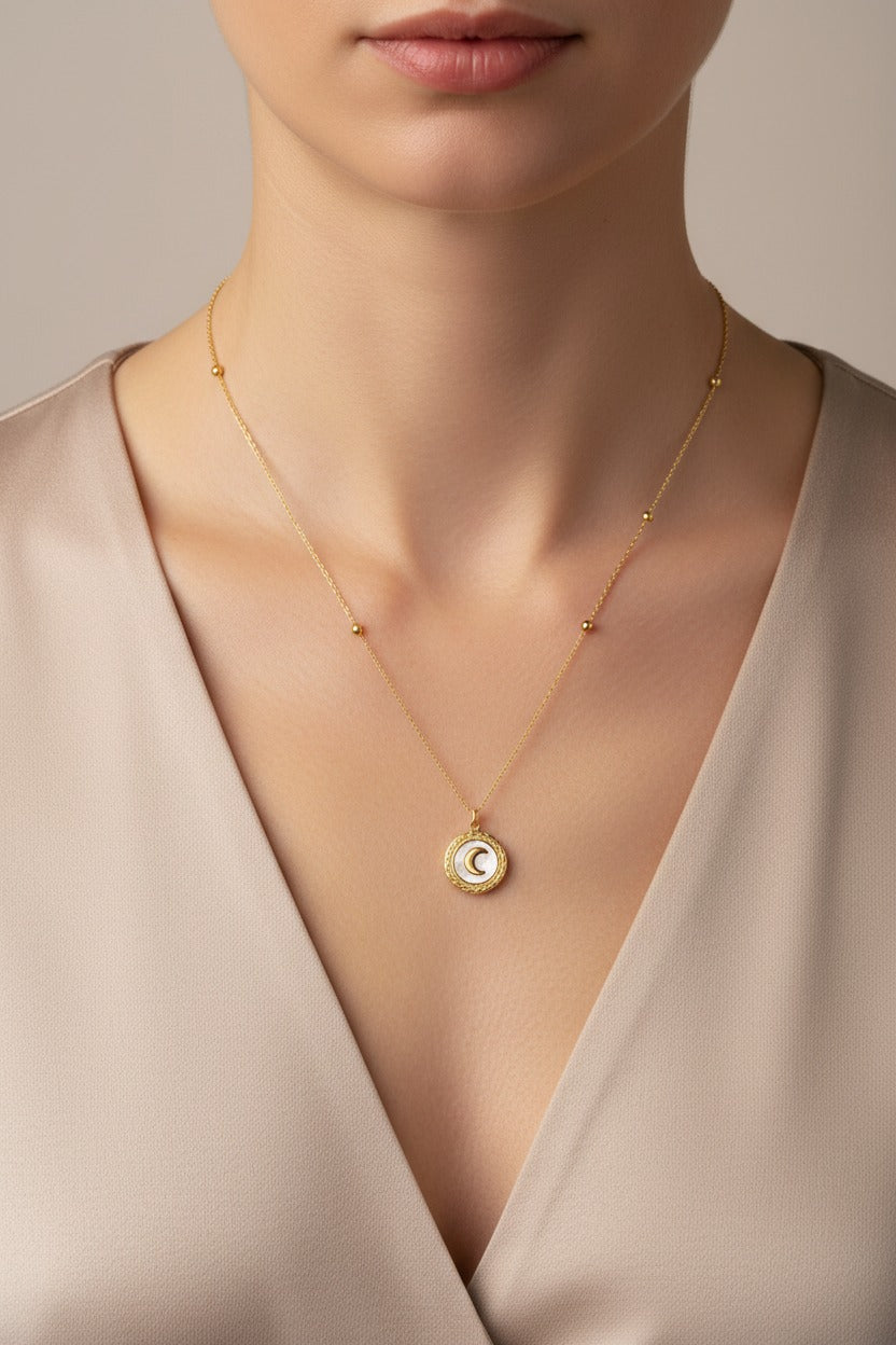 Crescent Moon Pendant Necklace crafted from stainless steel with 18K PVD gold plating, worn on model neckline