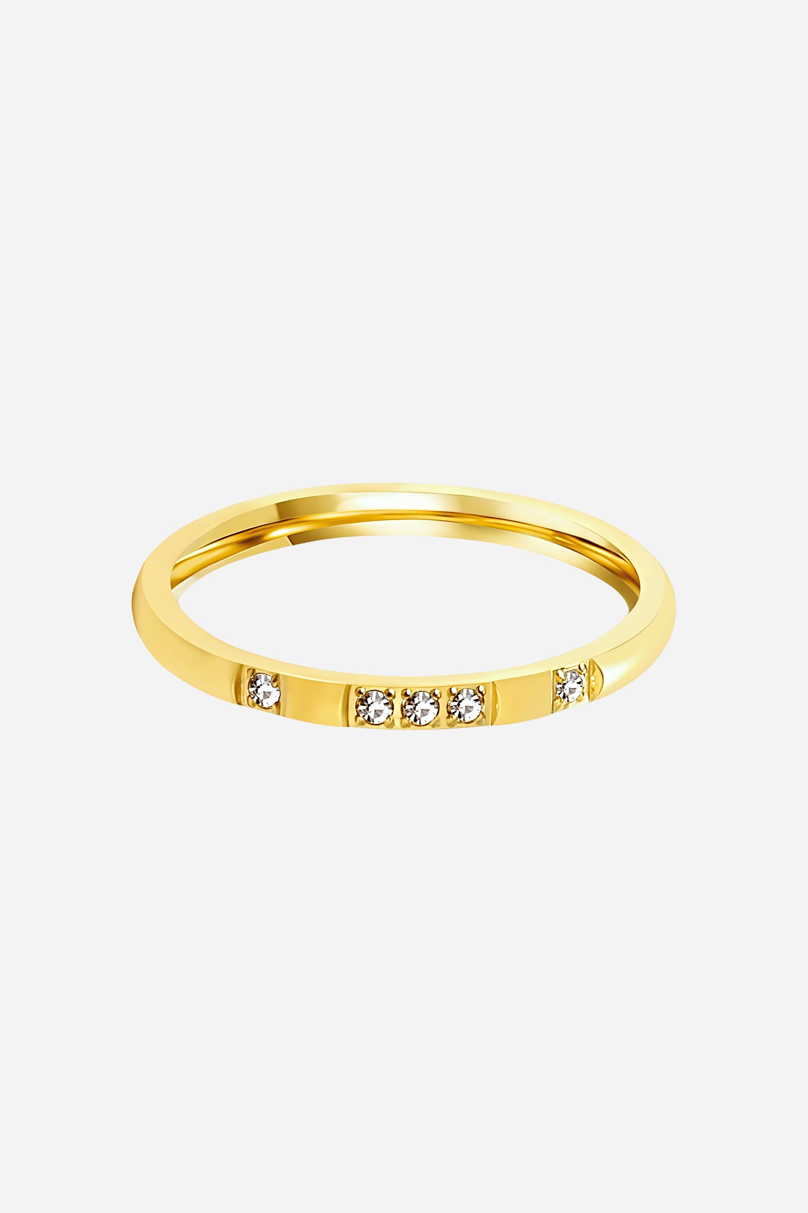 Top-view of GLISTIA slim gold band ring featuring a row of brilliant clear crystals.