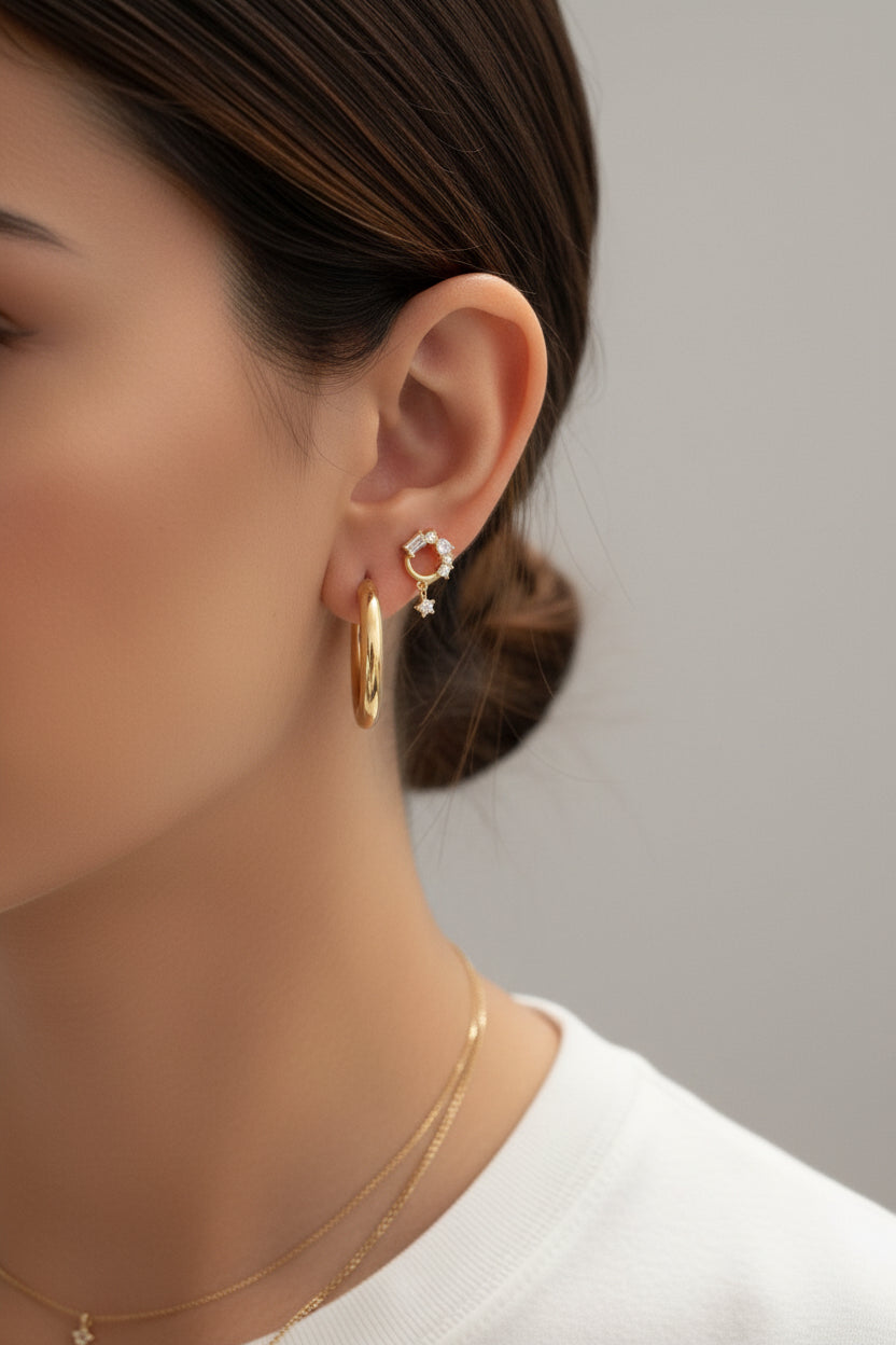 Crystal baguette circle piercing earrings crafted from stainless steel with 18K PVD gold plating, featuring an open circle design set with baguette and round cubic zirconia crystals