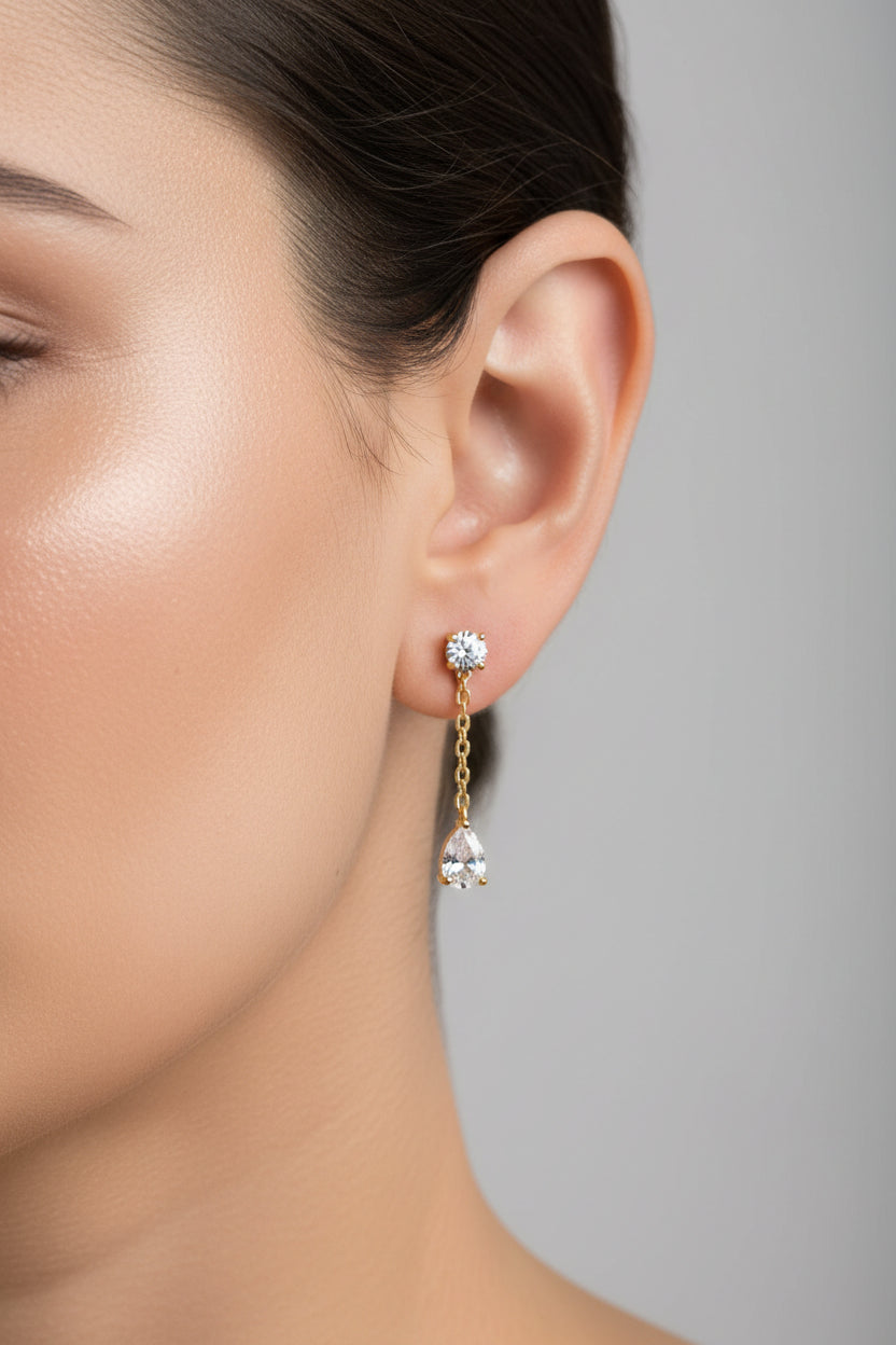 Dangle crystal chain stud earrings crafted from stainless steel with 18K PVD gold plating, featuring round and teardrop cubic zirconia crystals linked by a fine chain