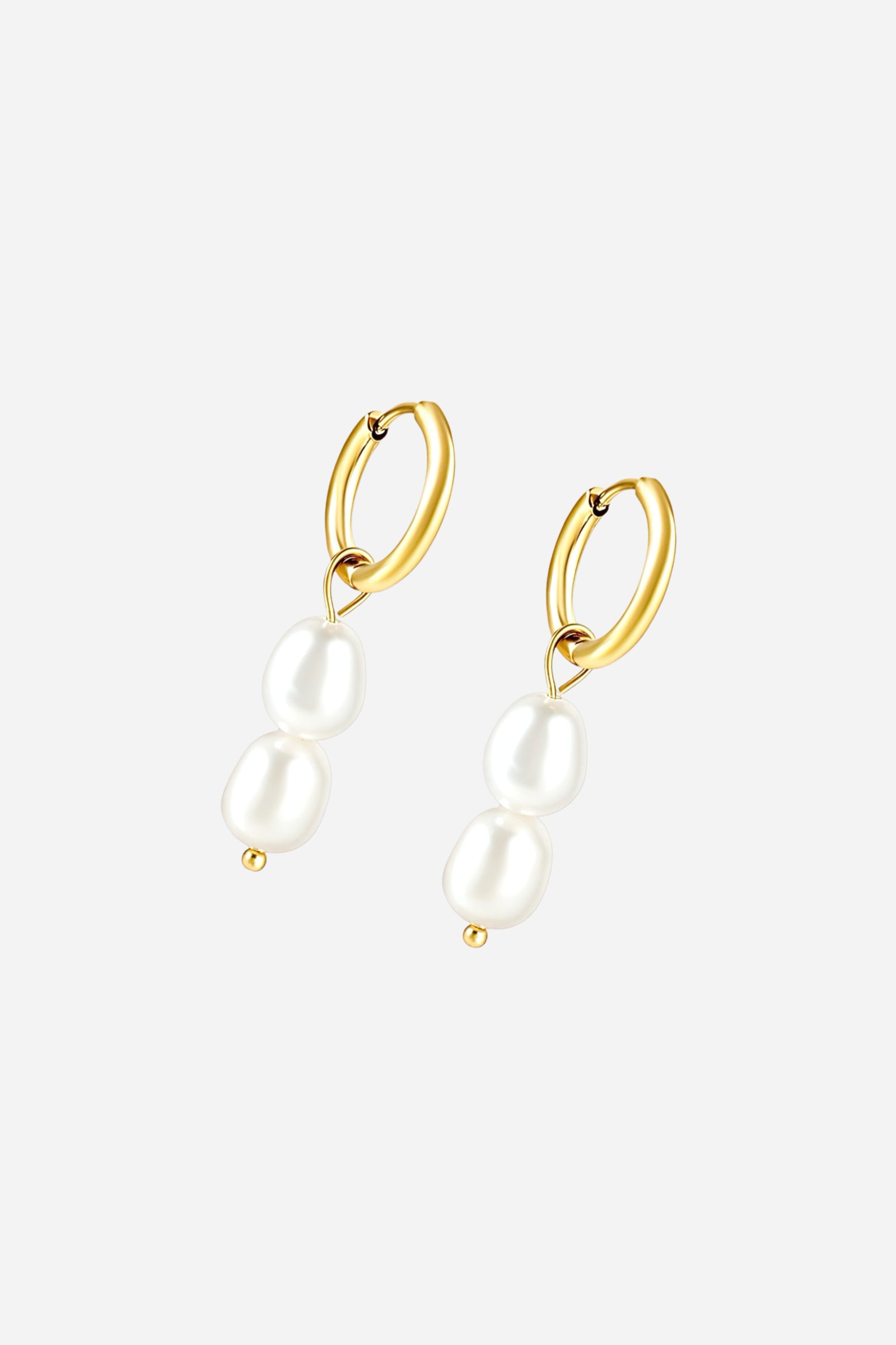 Angled view of double pearl drop huggie earrings featuring two lustrous white pearls suspended from PVD 18K gold plated stainless-steel hoops with a polished finish – GLISTIA.