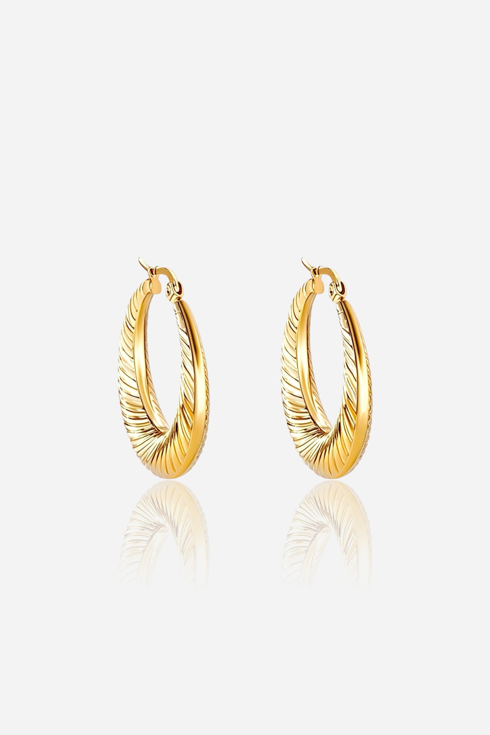 Close-up view of Elara Twist Hoop Earrings crafted from stainless steel with a radiant PVD 18K gold plated finish, featuring an elegant twisted design and reflective surface — GLISTIA.