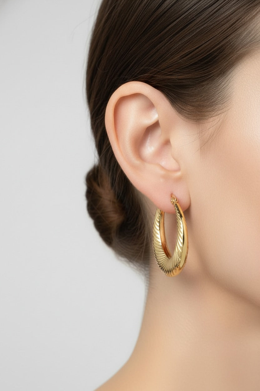 Side view of Elara twist hoop earrings in 18K PVD gold plated stainless steel, lightweight and water safe for everyday wear