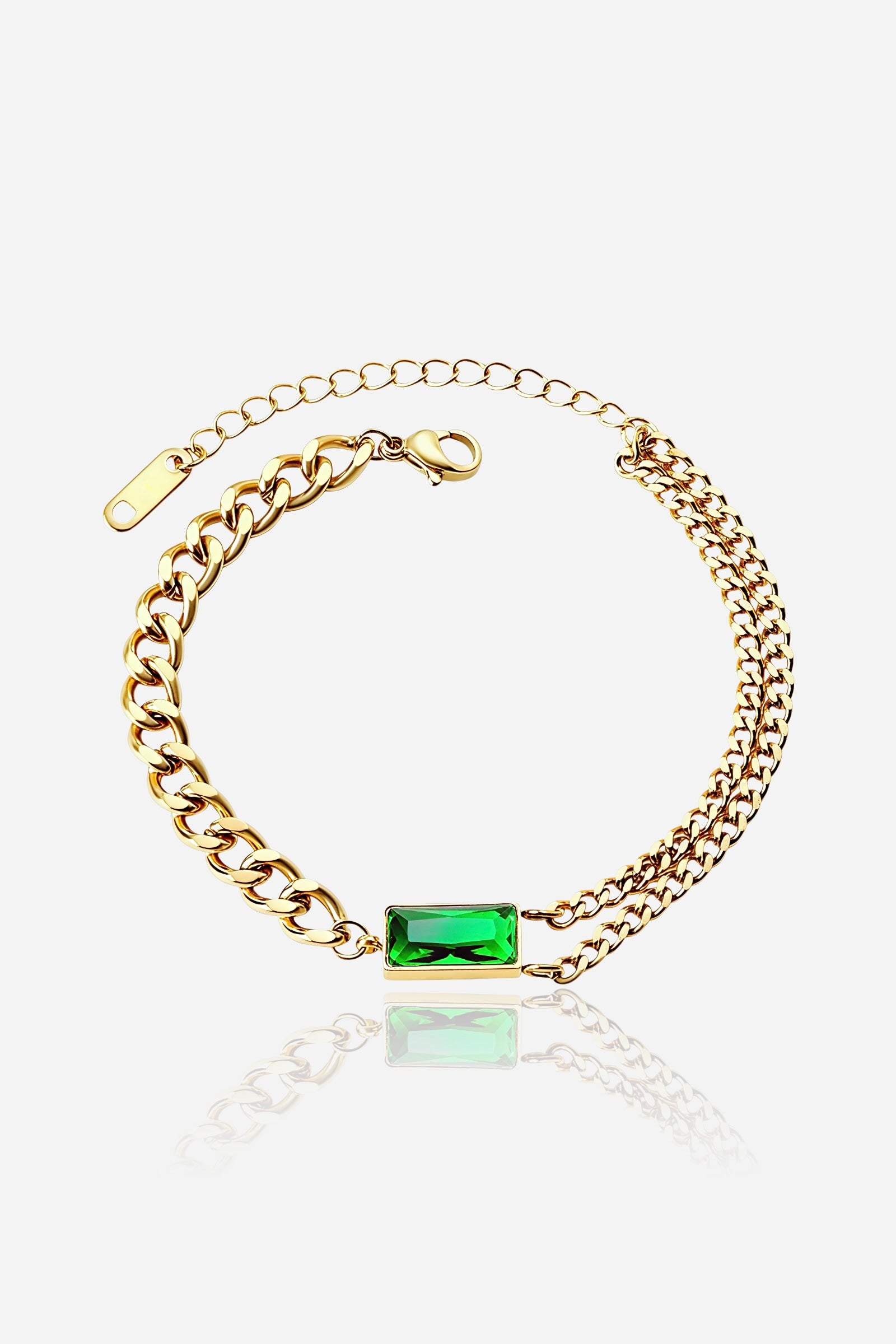 GLISTIA Emerald Glow dual chain bracelet in PVD 18K gold plated stainless steel shown from the front with an emerald-cut green stone.