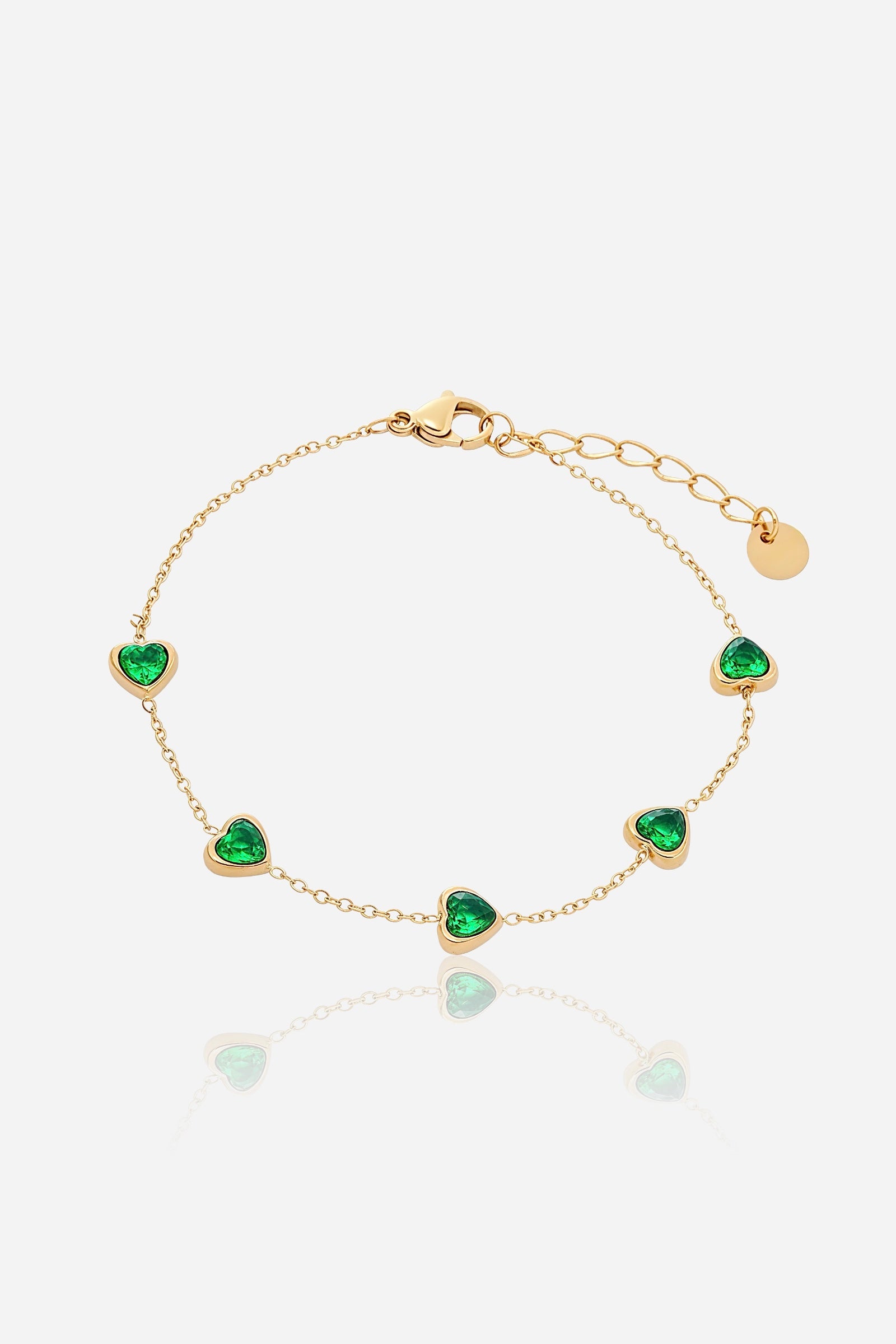 Top-view of GLISTIA’s delicate chain bracelet with multiple heart-cut green crystal charms.