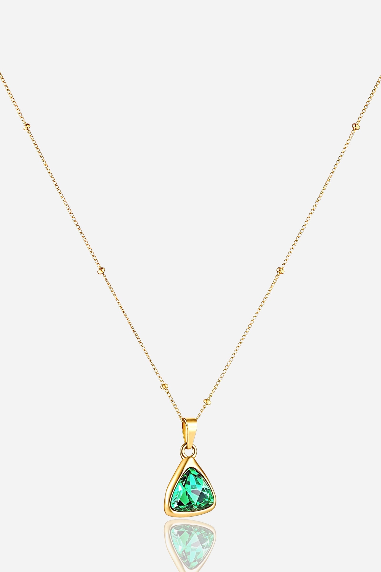 zoom-angle view of GLISTIA Emerald Radiance Pendant highlighting the faceted green stone and gold frame.