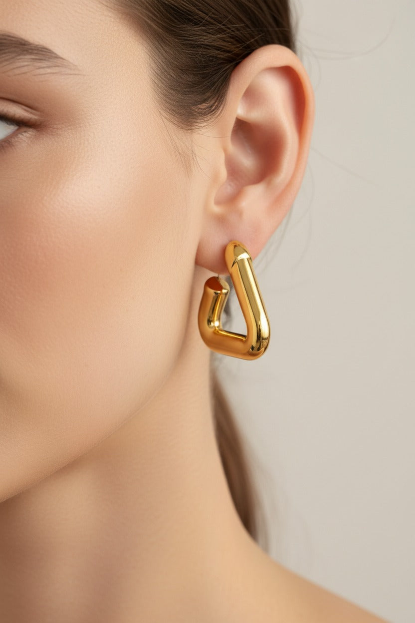 Geometric gold triangle hoop earrings crafted from stainless steel with 18K PVD gold plating, featuring a bold triangular silhouette and polished finish