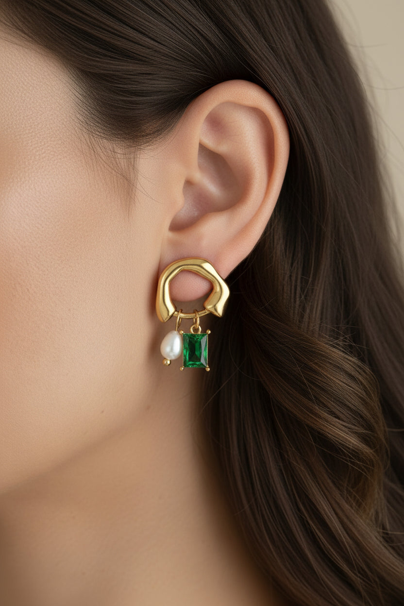Geometric drop earrings crafted from stainless steel with 18K PVD gold plating, featuring a freshwater pearl and emerald green cubic zirconia.
