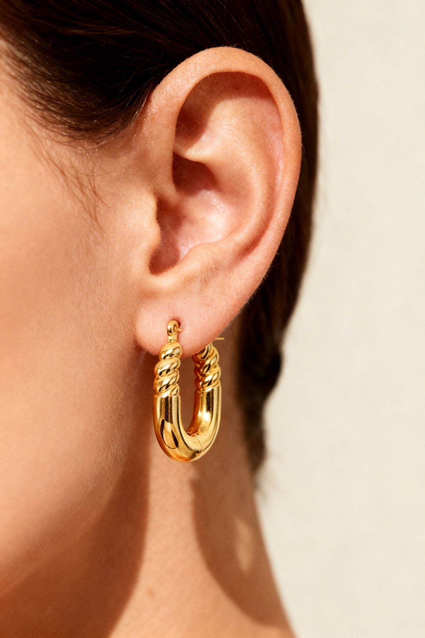 Side view of GLISTIA U-shaped twisted hoop earrings 18K PVD gold plated stainless steel