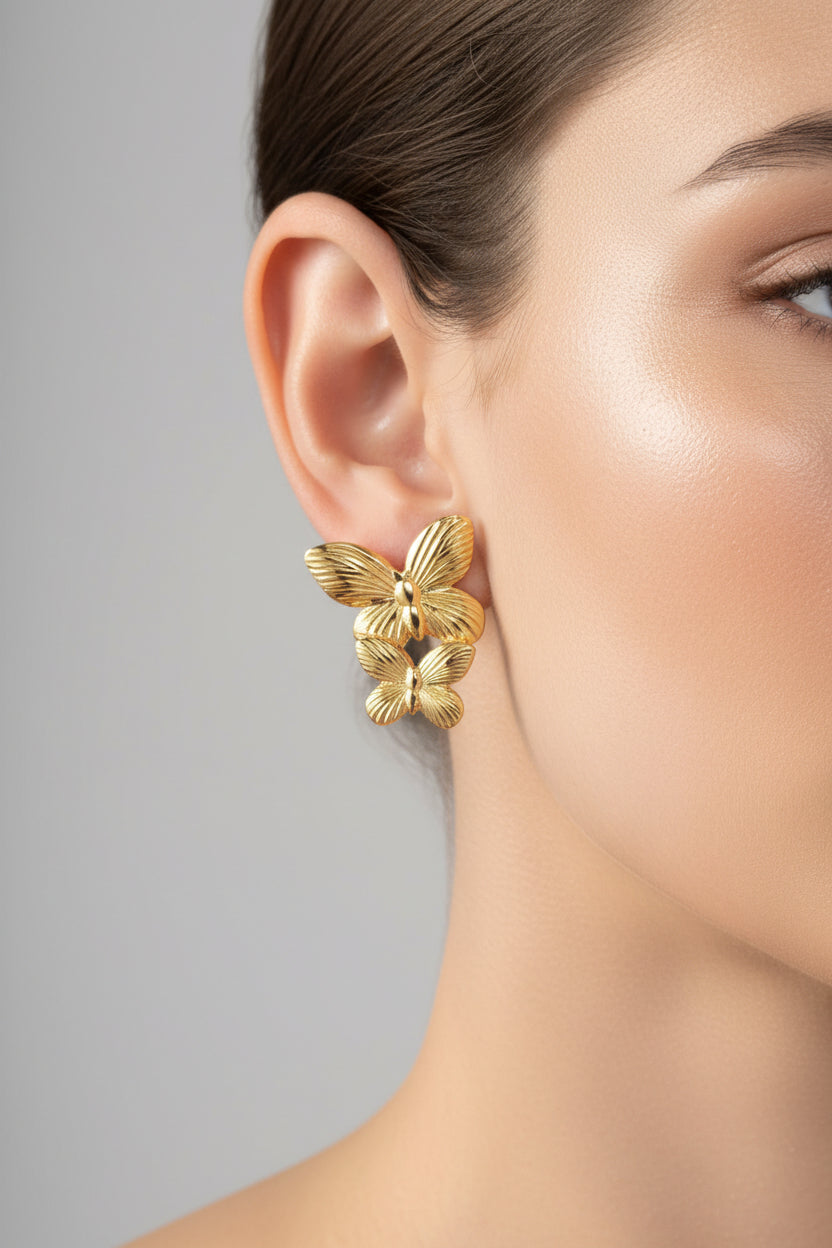 Gold butterfly stud earrings crafted from stainless steel with 18K PVD gold plating, featuring a delicate double butterfly design