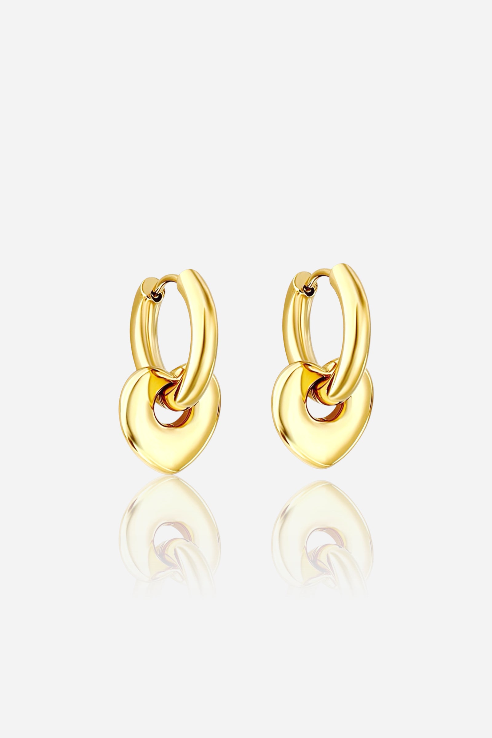 Angled view of gold heart charm hoop earrings crafted from stainless steel with a PVD 18K gold-plated finish, showcasing a smooth hoop and dangling heart charm – GLISTIA
