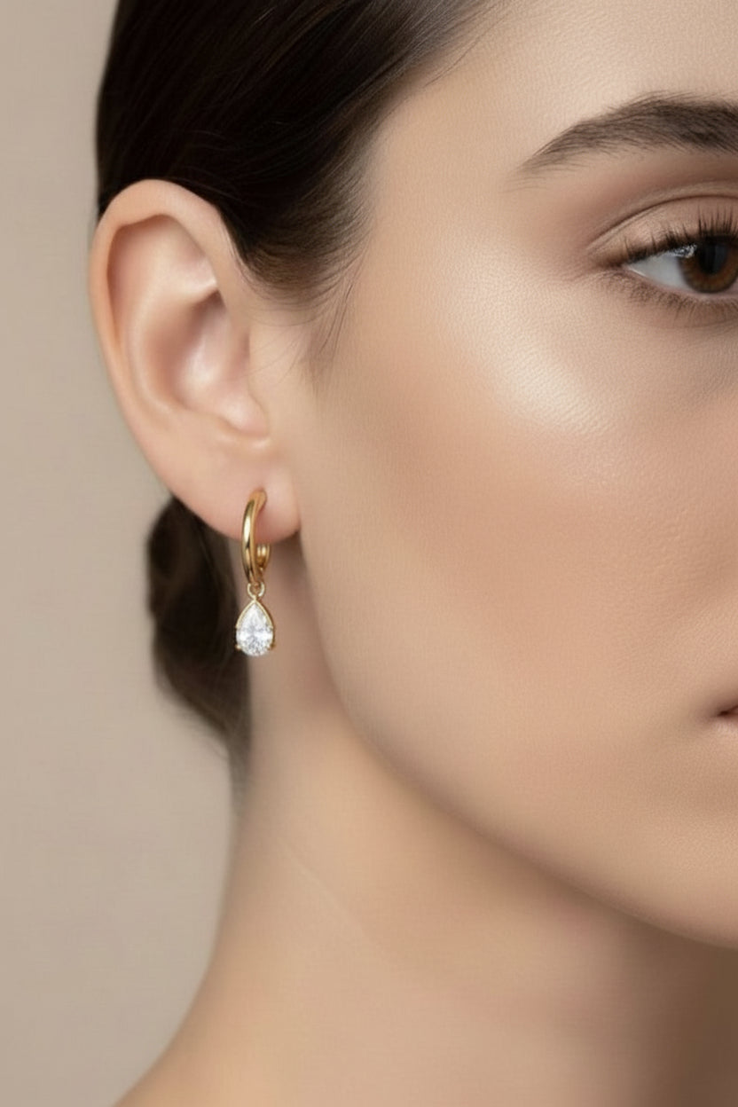 Right ear view of gold teardrop crystal drop hoop earring in 18K PVD gold plated stainless steel