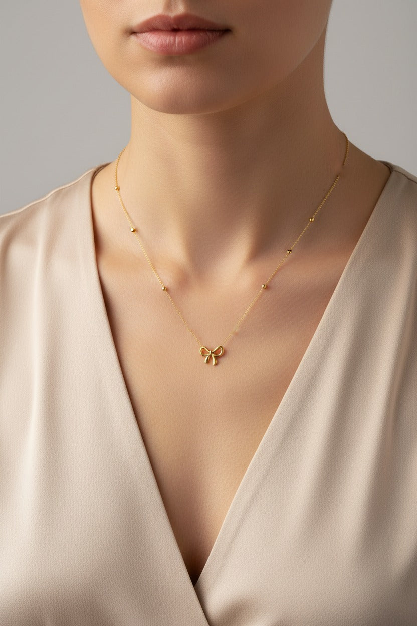Golden bow necklace in 18K PVD gold plated stainless steel with delicate bow pendant by GLISTIA
