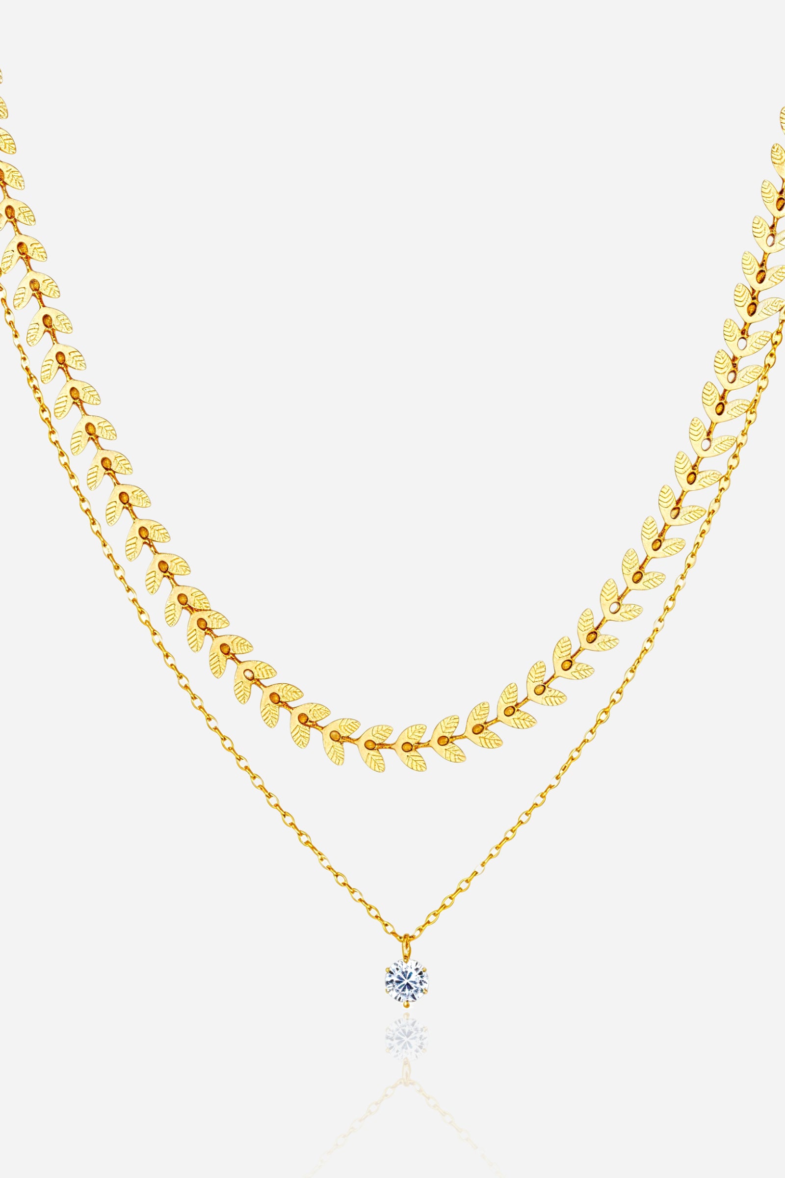 Front view of GLISTIA Golden Laurel Layered Necklace with leaf chain and crystal pendant.
