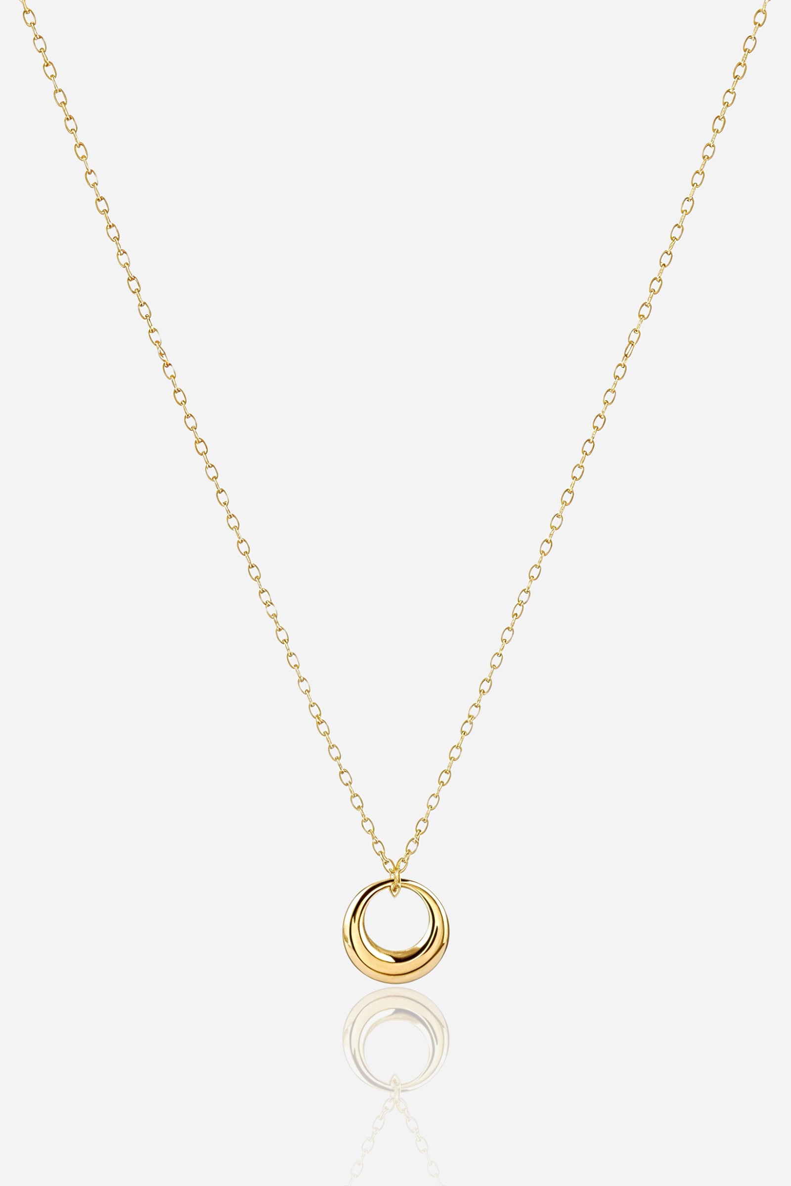 Zoom view of Golden Orbit Necklace showcasing glossy gold-tone circular pendant.
