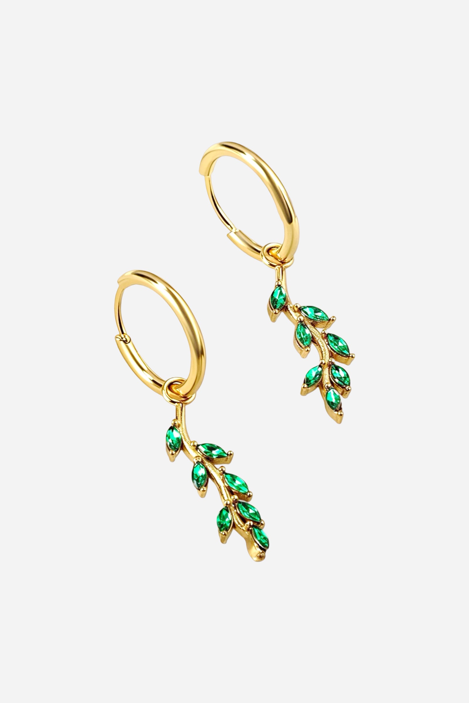 Angled view of green leaf dangle hoop earrings crafted from stainless steel with PVD 18K gold plating, featuring cascading leaf motifs set with green zirconia crystals – GLISTIA.