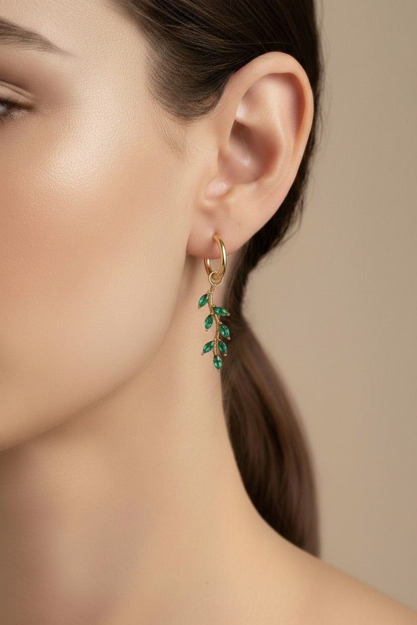 Green leaf dangle hoop earrings crafted from stainless steel with 18K PVD gold plating, featuring cascading marquise-cut green cubic zirconia crystals.