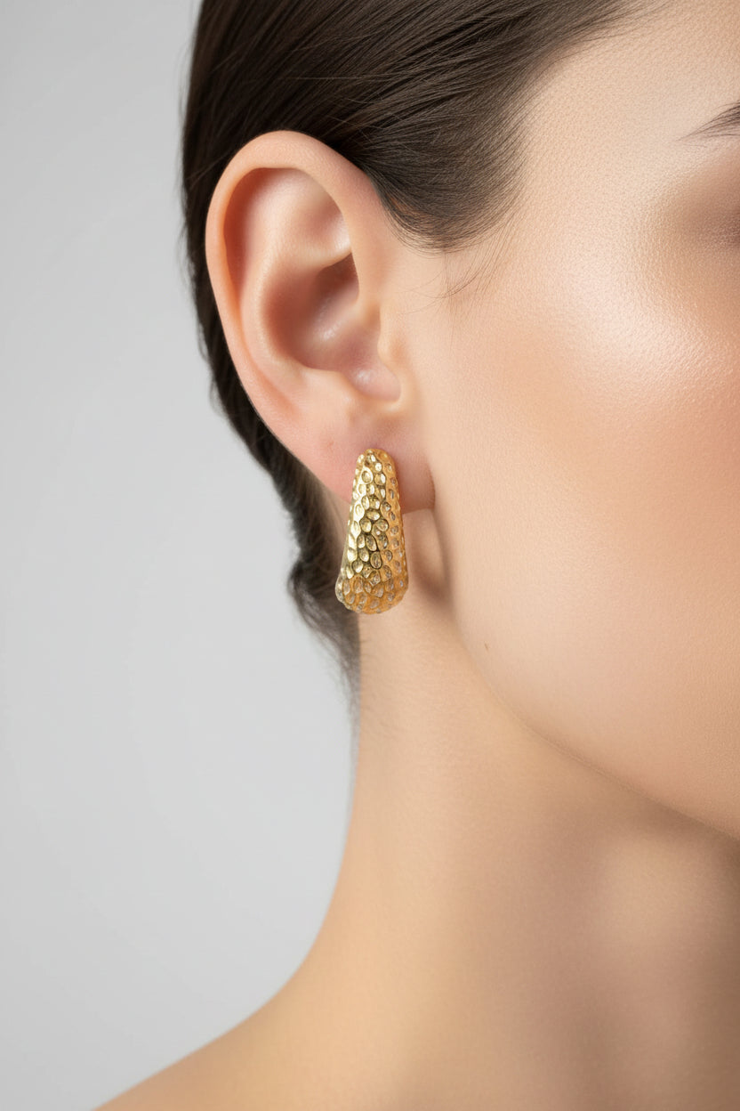 Hammered 18K PVD gold plated stud earrings worn on ear, showcasing curved textured finish and modern everyday elegance