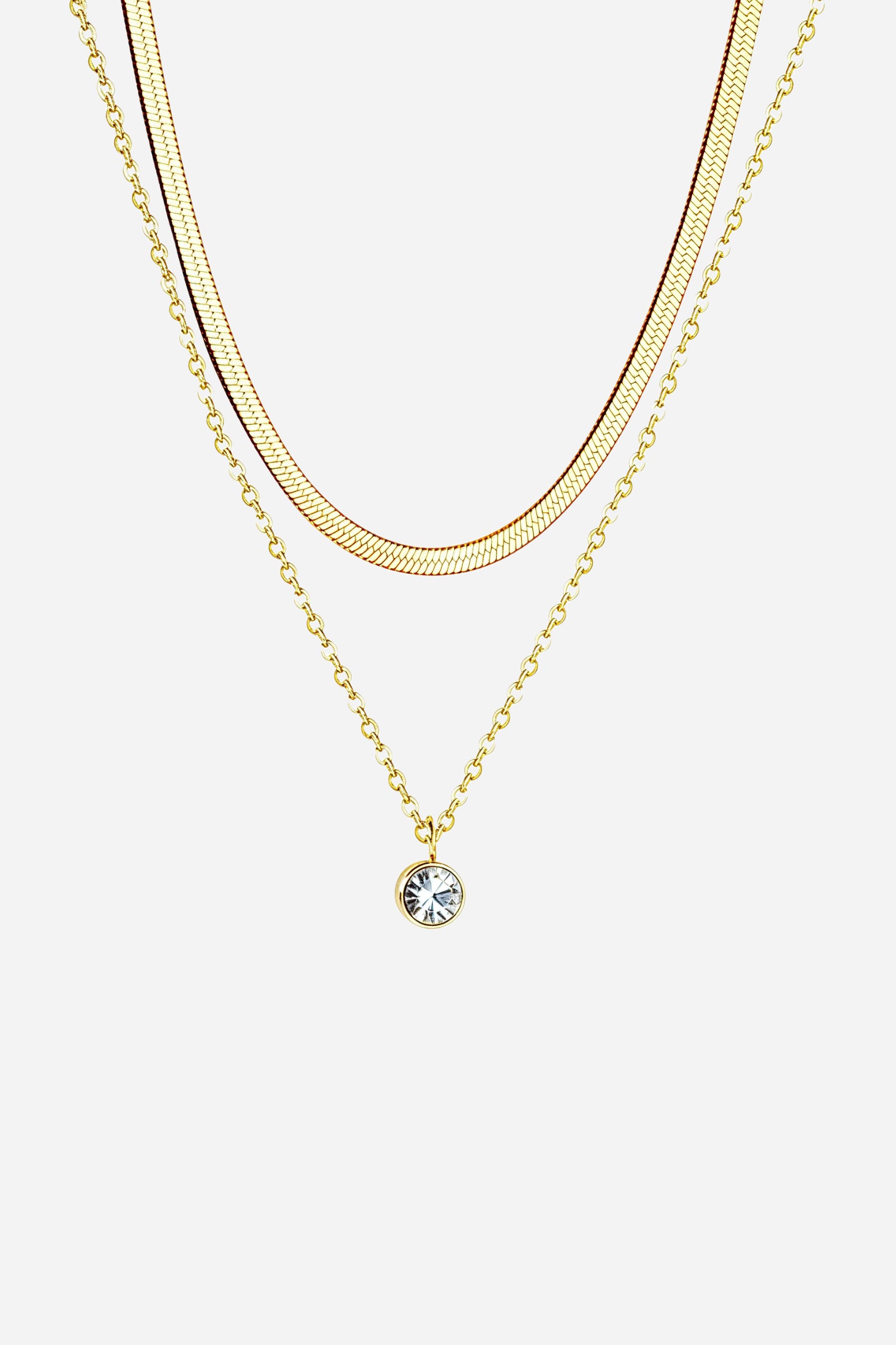 Top-view image of GLISTIA dual-layer necklace featuring gold snake chain and crystal charm.