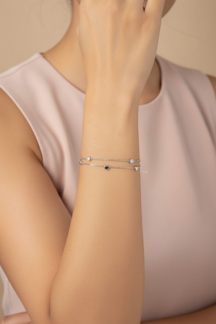 Close-up of stainless steel double layer bracelet with heart charm and crystal chain detailing
