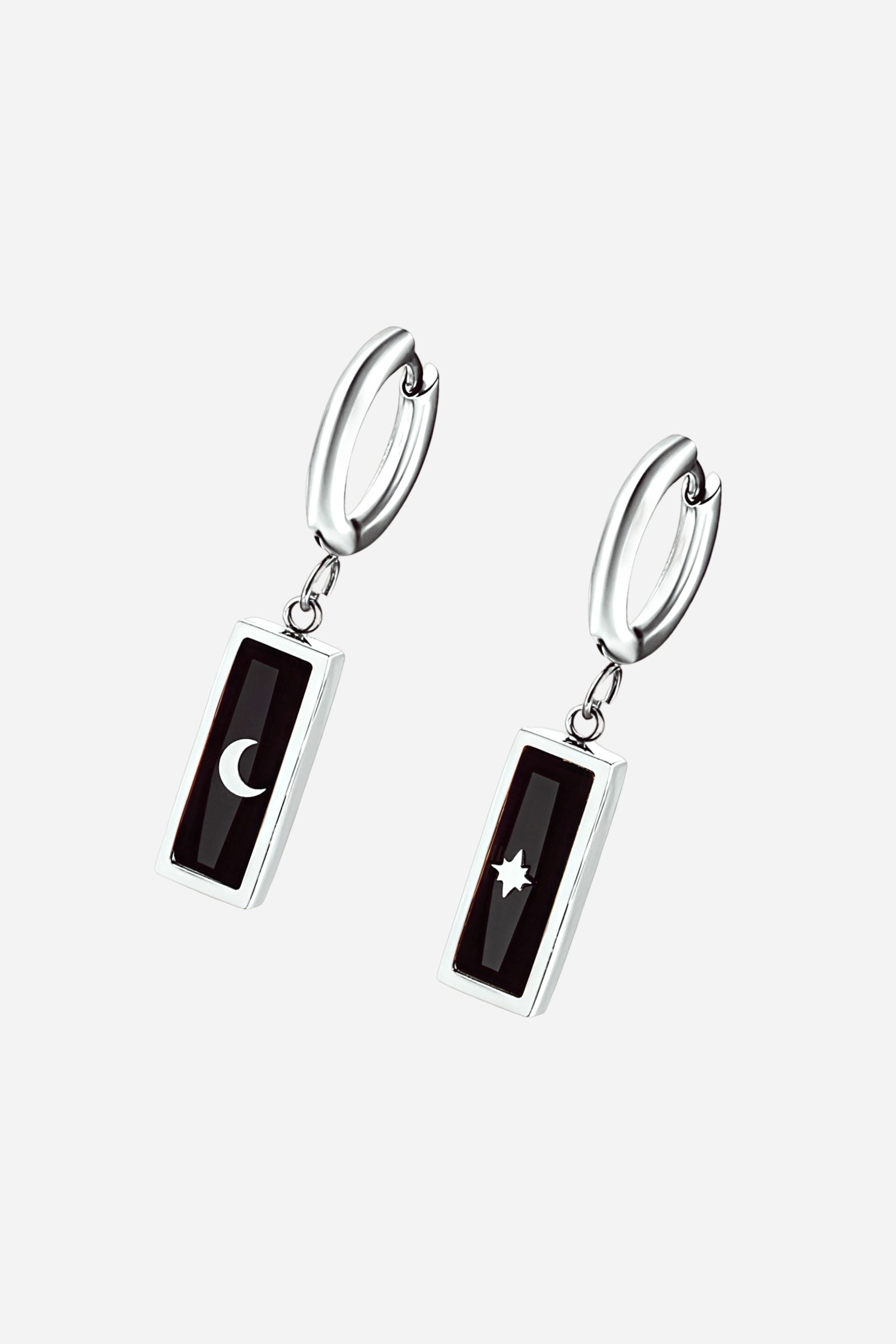 Pair of polished silver-tone stainless-steel hoop earrings featuring rectangular black enamel charms engraved with moon and star motifs – GLISTIA.