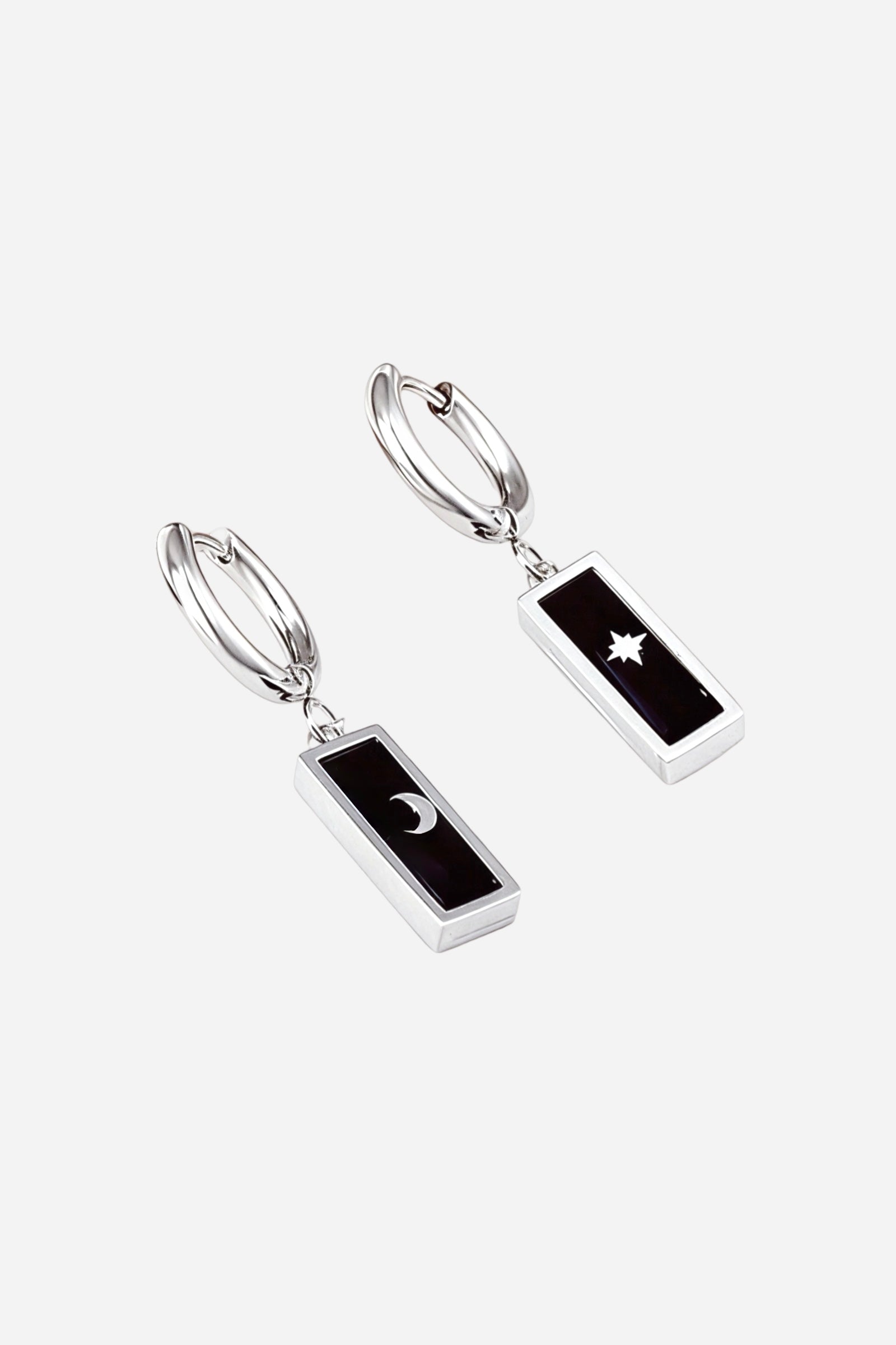 Polished silver-tone stainless-steel hoop earrings featuring rectangular black enamel charms with moon and star cut-out motifs – GLISTIA