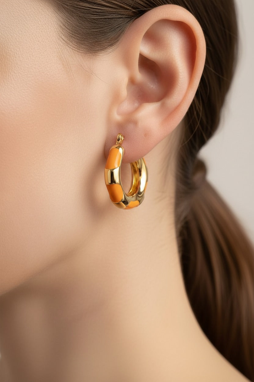 Orange bamboo hoop earrings crafted from stainless steel with 18K PVD gold plating, featuring a bamboo-inspired design and vibrant orange enamel detailing