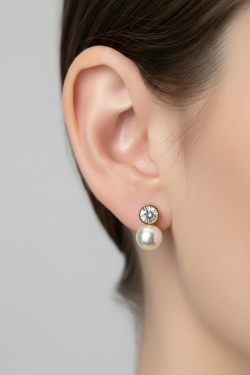 Pearl drop stud earrings crafted from stainless steel with 18K PVD gold plating, featuring a rhinestone-set stud and smooth pearl-style drop.