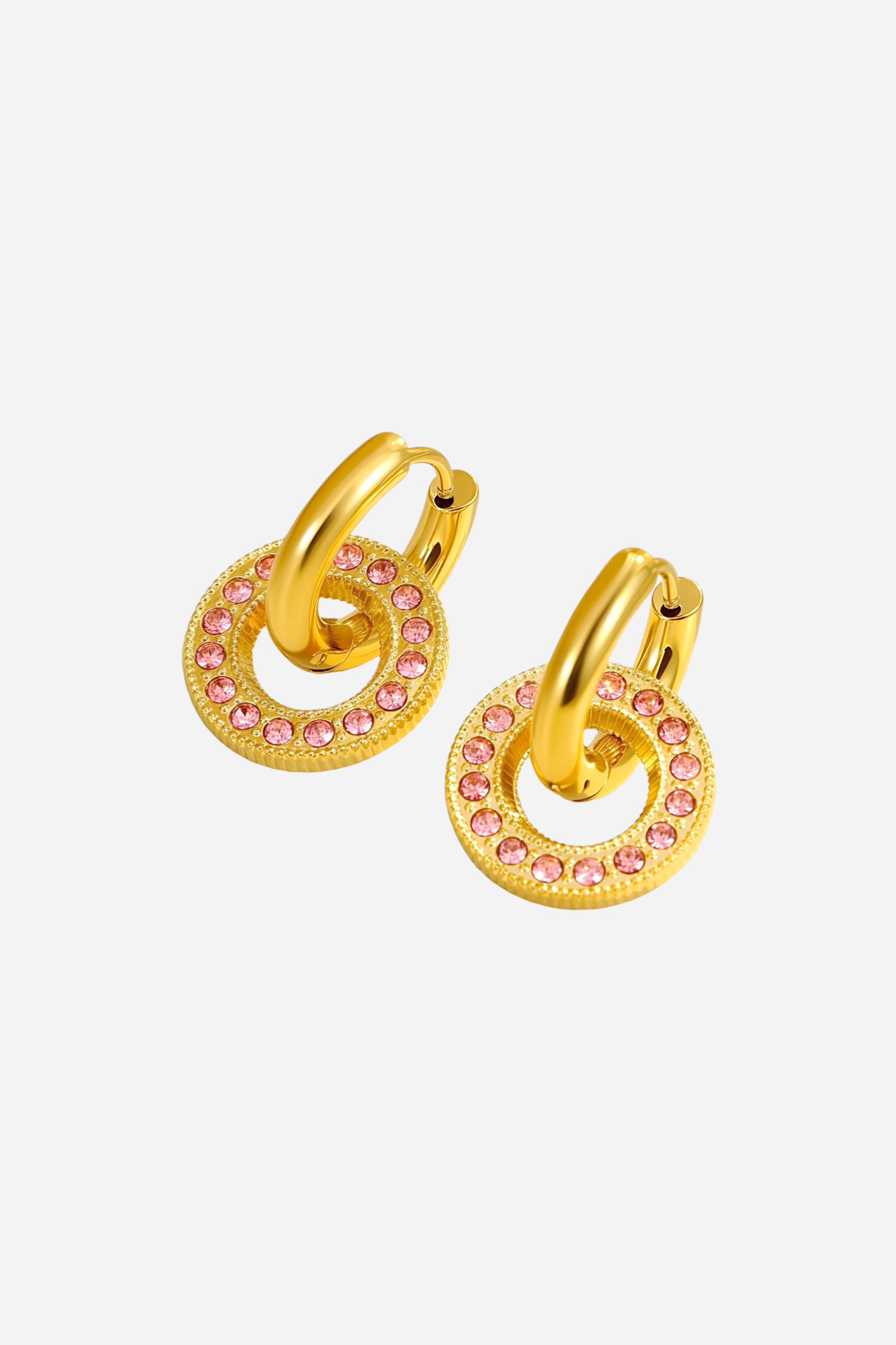 Angled top view of pink crystal circle hoop earrings featuring a gold-tone drop ring with embedded pink stones, crafted from stainless steel and plated in radiant PVD 18K gold – GLISTIA.