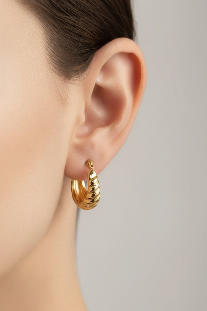 Ribbed gold hoop earrings crafted from stainless steel with 18K PVD gold plating, featuring a bold sculptural design and textured finish