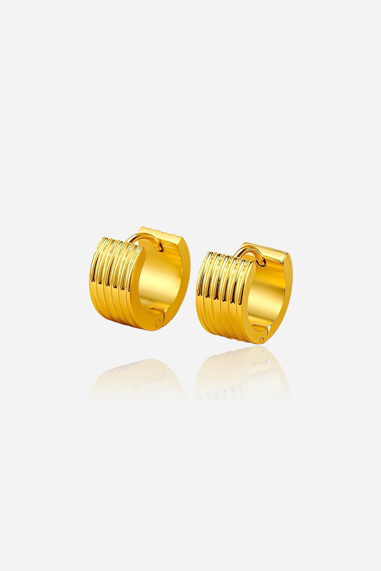 Ribbed huggie hoop earrings crafted from premium stainless steel with a lustrous PVD 18K gold plated finish, featuring fine linear grooves and a sleek rounded silhouette for a modern, polished look – GLISTIA.