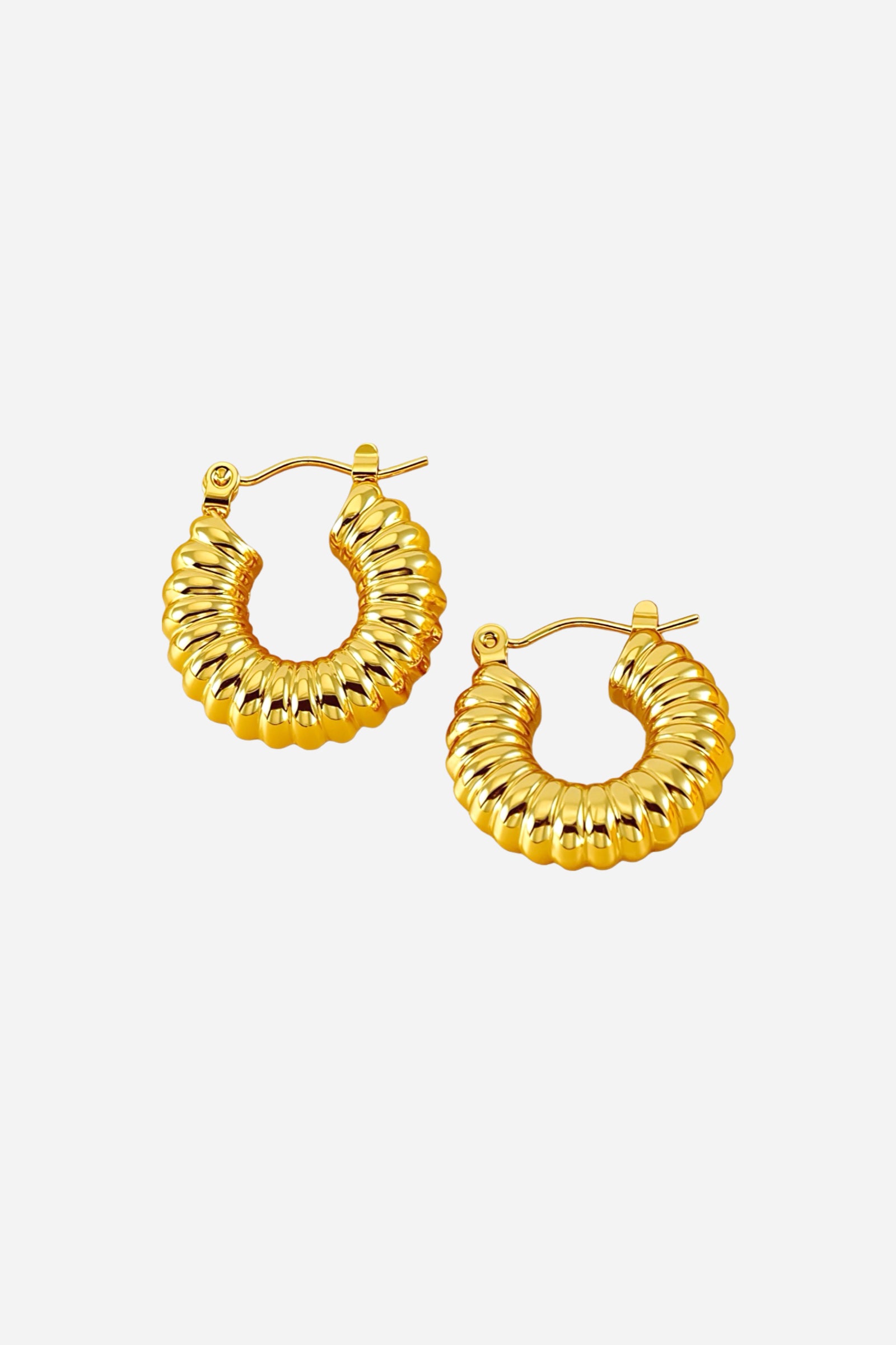 Angle view of ribbed textured hoop earrings crafted from stainless steel with a lustrous PVD 18K gold plated finish, showcasing sculpted ridges and a rounded hoop silhouette – GLISTIA.