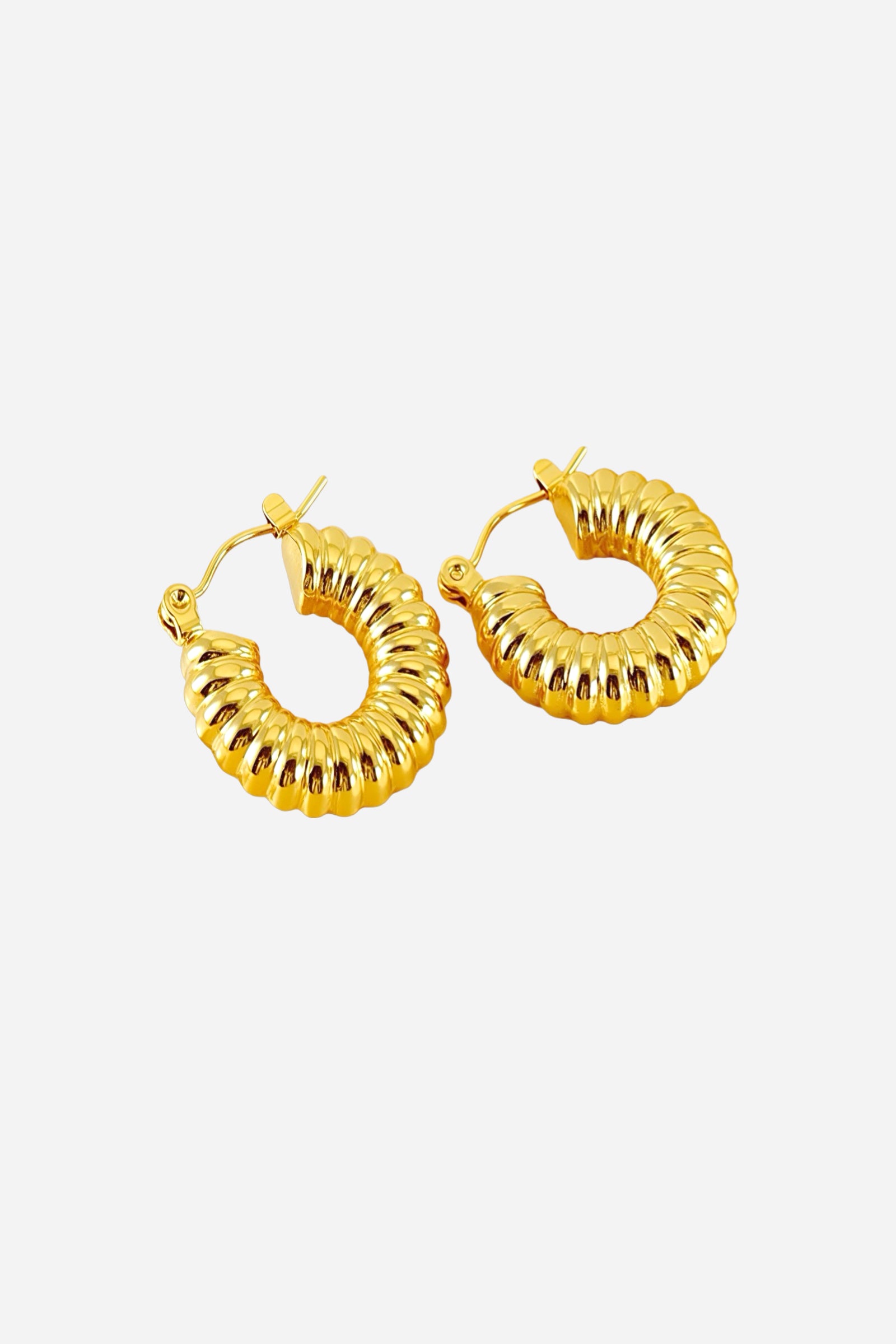 Top view of ribbed textured hoop earrings crafted from stainless steel with a lustrous PVD 18K gold plated finish, featuring sculpted ridges and a curved hoop silhouette – GLISTIA.