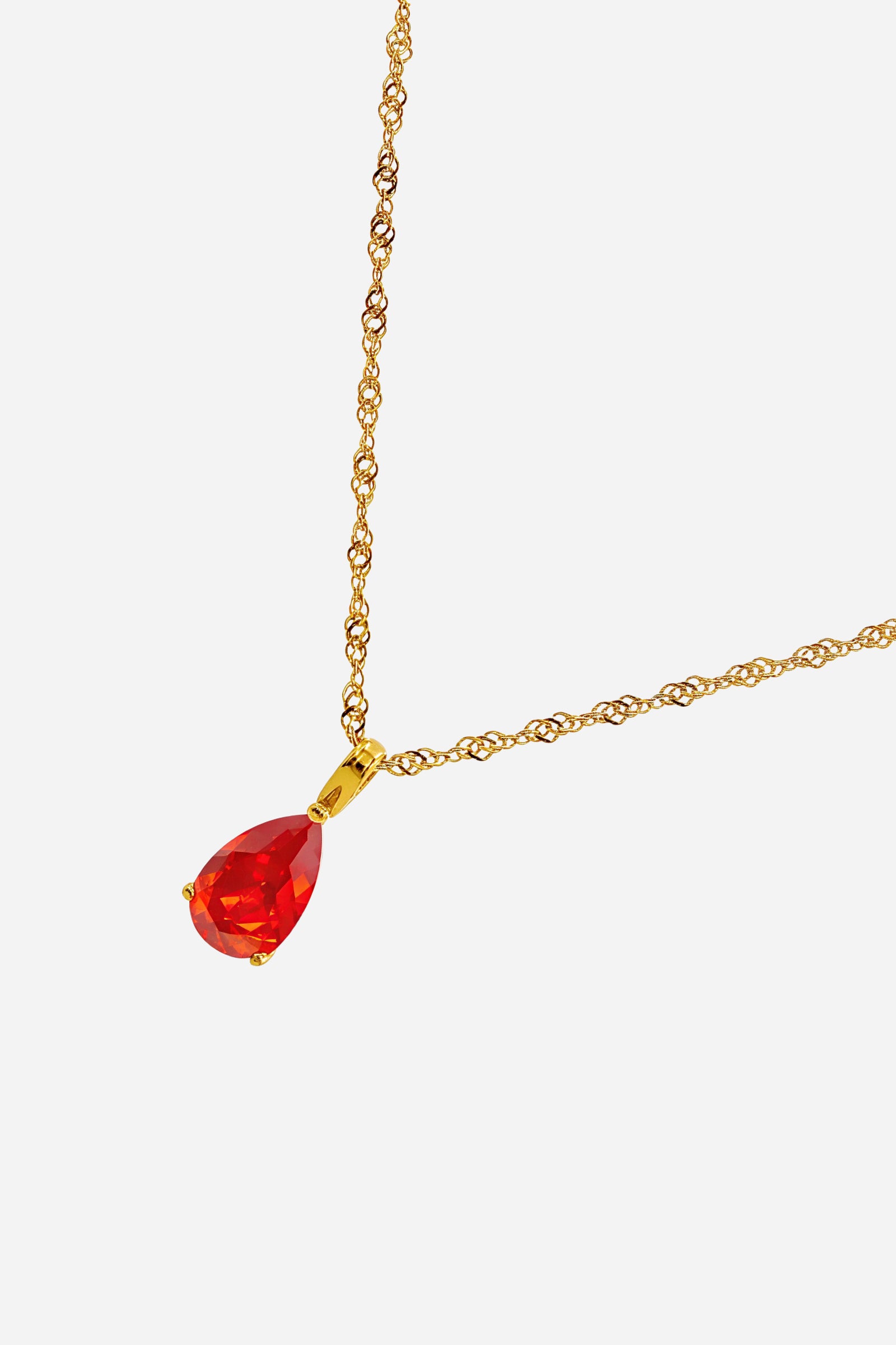 Close-up of the Siam Birthstone Necklace January showing the faceted Siam red crystal and polished 18K gold plated bezel.