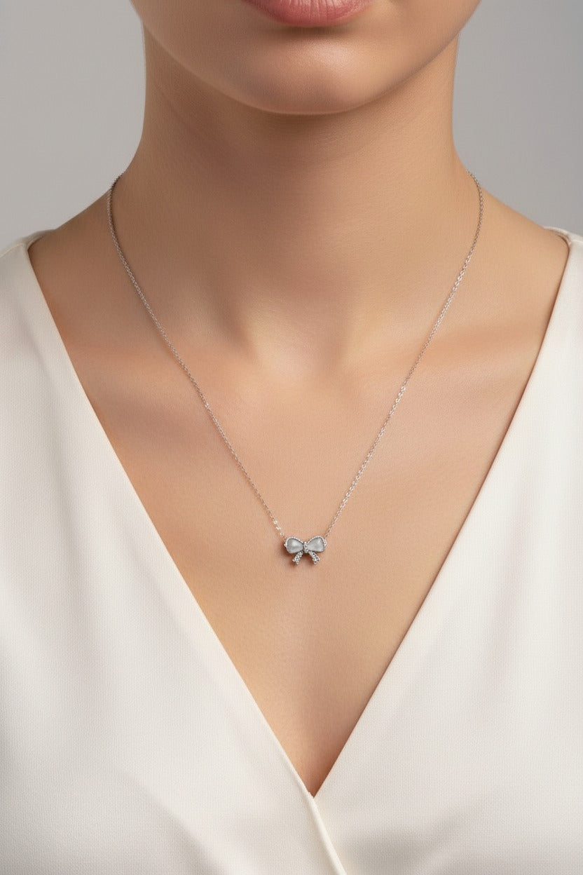 Close-up of silver bow pendant necklace in stainless steel