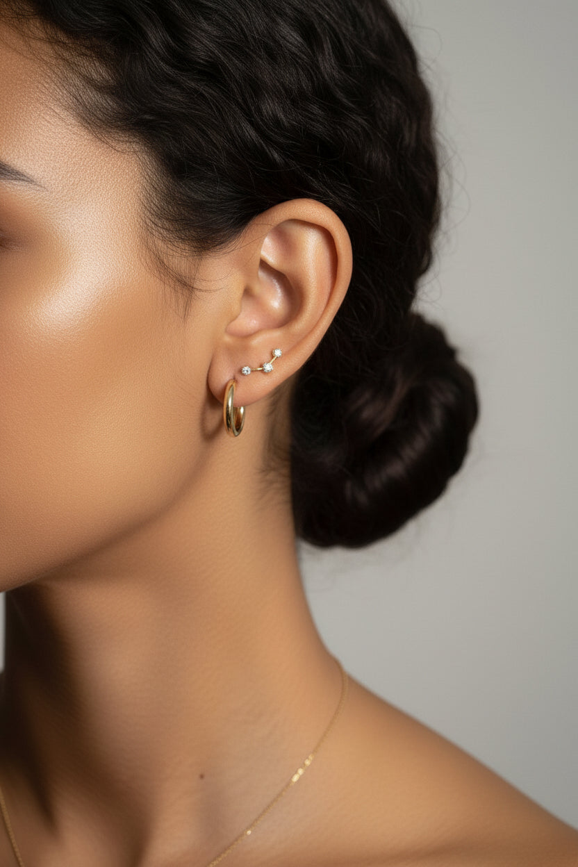Star curve crystal stud earrings worn on ear, showcasing curved bar star design with cubic zirconia stones in 18K PVD gold plated stainless steel
