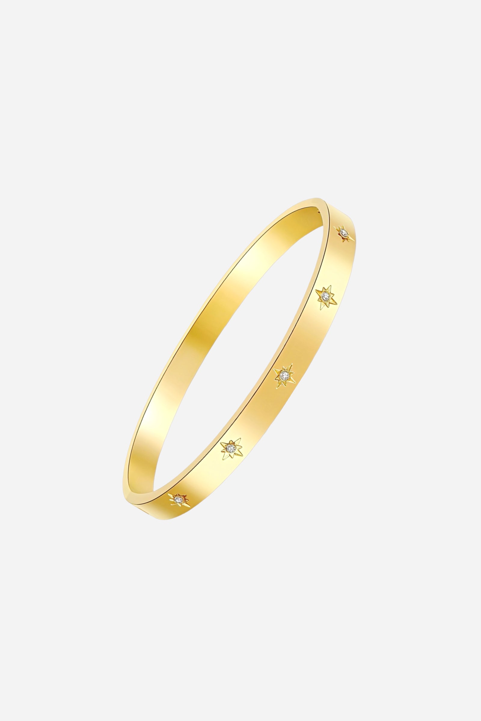 Top angle of GLISTIA gold starburst bangle highlighting the symmetrical engraved star designs and subtle crystal detailing along the polished gold surface