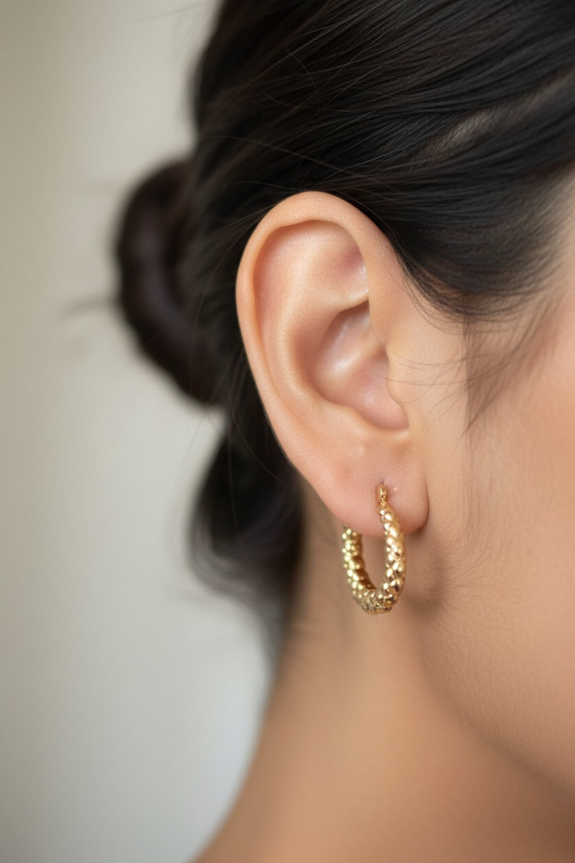 Textured dome hoop earrings in 18K PVD gold plated stainless steel featuring a bold dome shape, polished finish, and intricate textured surface