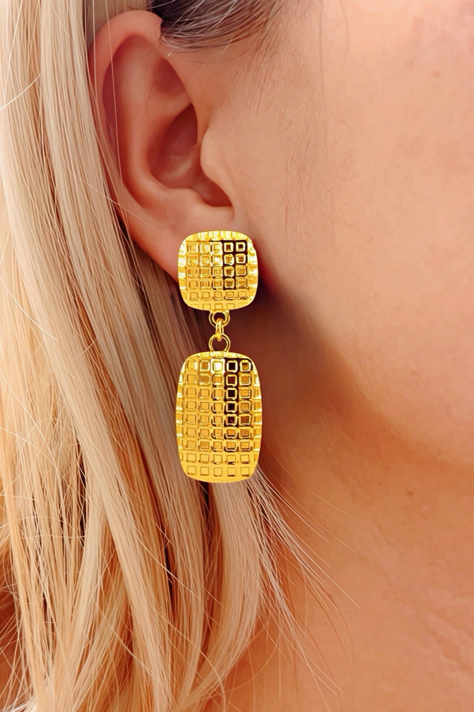 Front view of textured geometric drop earrings crafted from stainless steel with PVD 18K gold plating, featuring a grid-patterned rectangular drop and matching stud – GLISTIA.