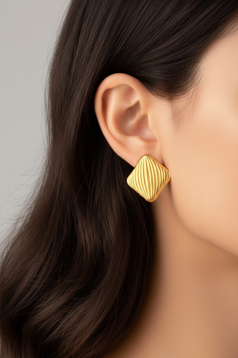 Textured square stud earrings crafted from stainless steel with 18K PVD gold plating, featuring a sculpted wave pattern and polished finish